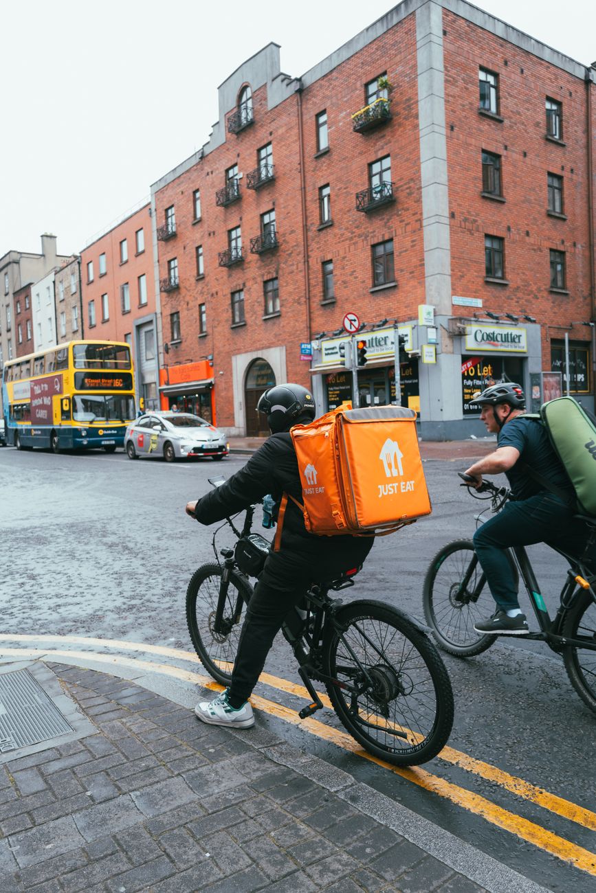 Delivery cyclists riding through an urban street